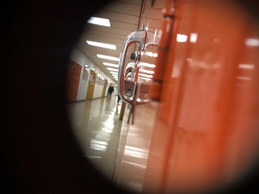 A great shot of looking through  a hole in a locker taking in the high school hallway. 